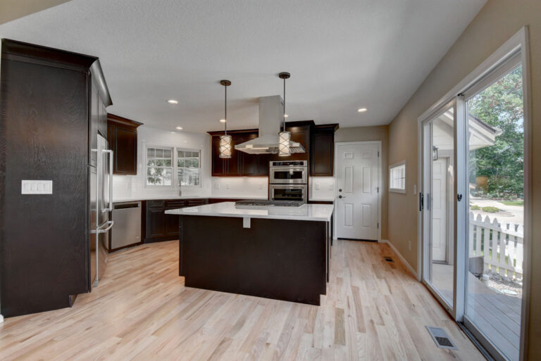 Fully remodeled Denver kitchen with dark cabinets, large center island, and pendant lights.