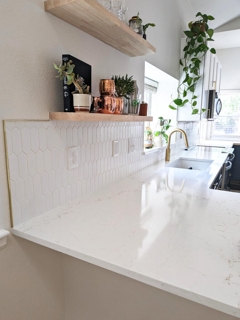 Remodeled Denver kitchen with new quartz countertop and vertical picket-shaped white tile backsplash.