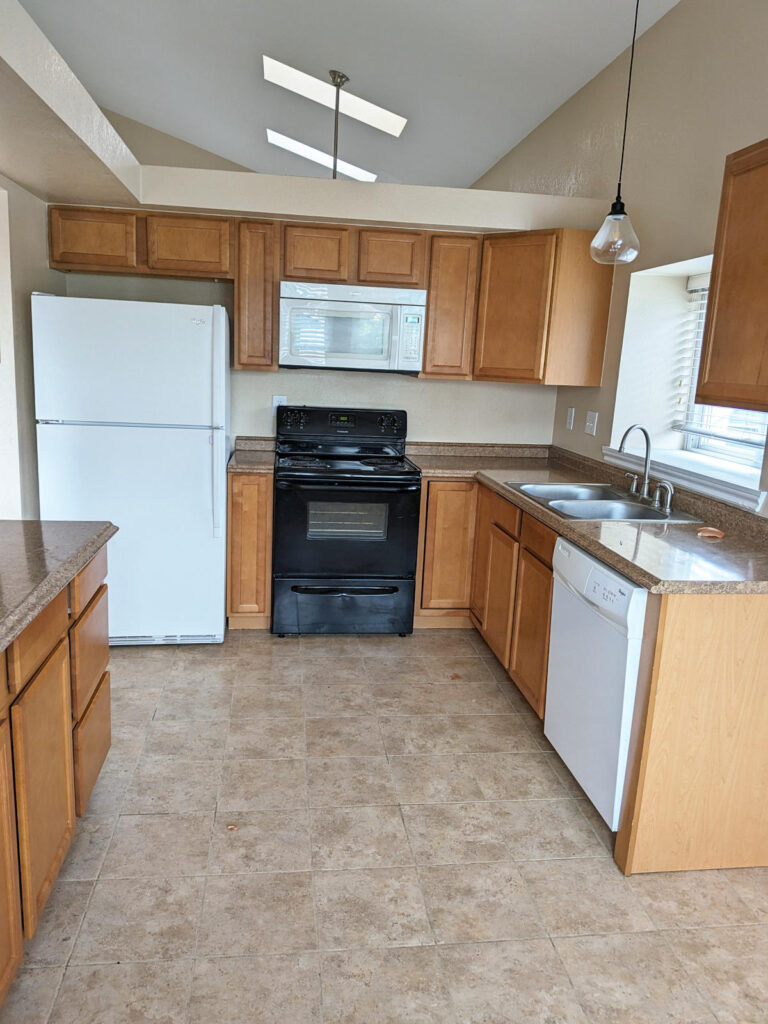 Denver kitchen before remodeling, with laminate countertops, wood cabinets, and white appliances.