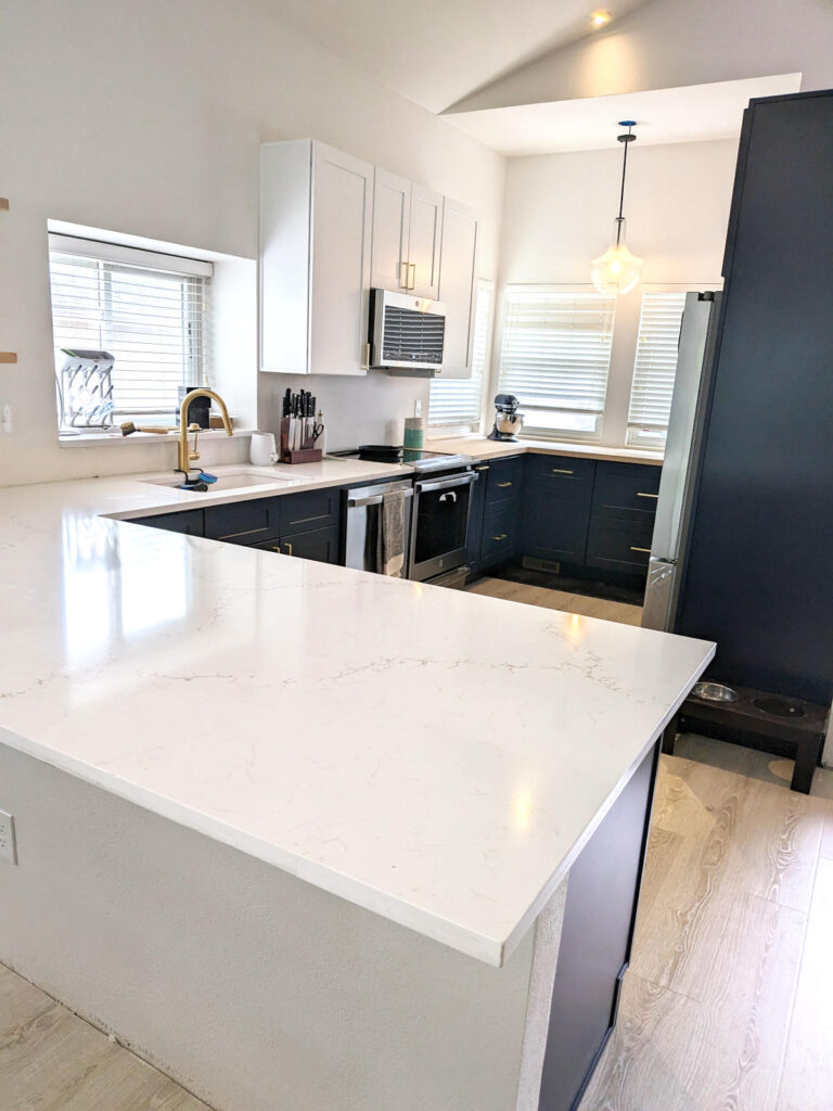 Denver remodeled kitchen with white quartz countertop peninsula with overhang for bar stools.